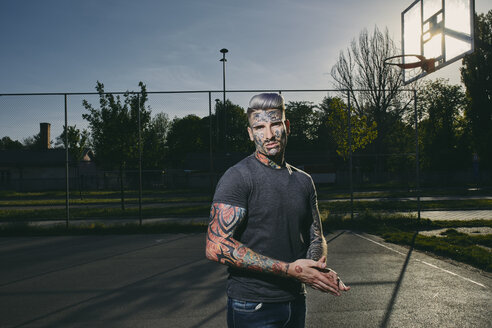 Porträt eines tätowierten jungen Mannes auf dem Basketballplatz - ZEDF01428