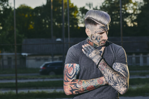Portrait of tattooed young man outdoors stock photo