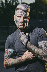 Portrait of tattooed young man outdoors - ZEDF01450