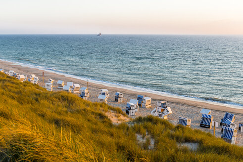 Deutschland, Schleswig-Holstein, Sylt, Strand und leere Strandkörbe mit Kapuze bei Sonnenuntergang - EGBF00249