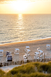 Germany, Schleswig-Holstein, Sylt, beach and empty hooded beach chairs at sunset - EGBF00250