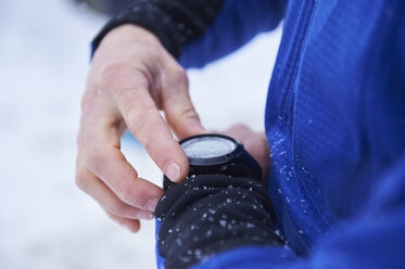 Nahaufnahme der Hand eines männlichen Skifahrers, der seine Smartwatch überprüft, Gstaad, Schweiz - CUF04764