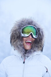 Portrait of happy mature woman in falling snow, Gstaad, Switzerland - CUF04779