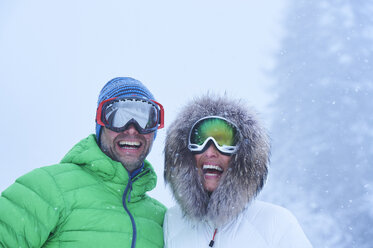 Porträt eines glücklichen reifen Paares im fallenden Schnee, Gstaad, Schweiz - CUF04781