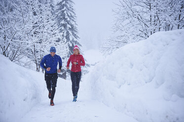 Läuferinnen und Läufer beim Laufen im fallenden Schnee, Gstaad, Schweiz - CUF04789