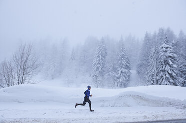 Entfernte Ansicht eines männlichen Läufers im Tiefschnee, Gstaad, Schweiz - CUF04795