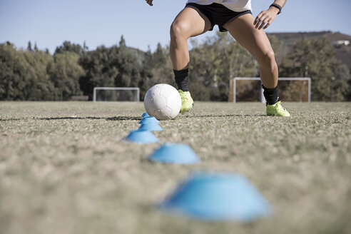 Cropped view of woman dribbling football - ISF01137