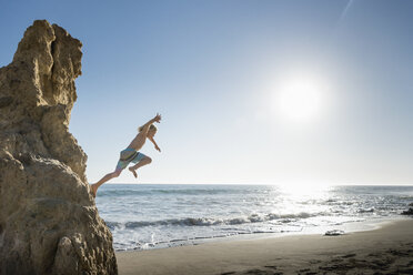 Boy jumping off rock, El Matador Beach, Malibu, USA - ISF01234