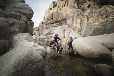 Kinder spielen auf Steinen im Fluss, Lake Arrowhead, Kalifornien, USA - ISF01246