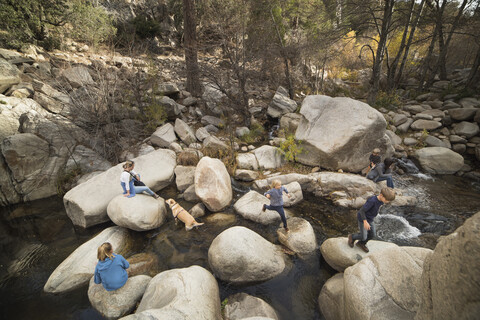 Familie spielt auf Felsen im Fluss, Lake Arrowhead, Kalifornien, USA, lizenzfreies Stockfoto