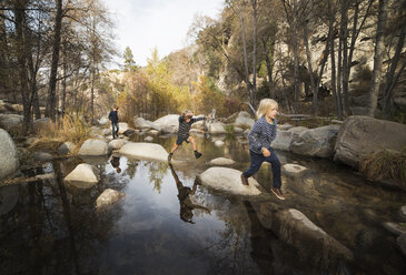 Kinder spielen auf Steinen im Fluss, Lake Arrowhead, Kalifornien, USA - ISF01248