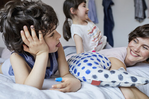 Mutter, Sohn und Tochter, die sich im Schlafzimmer entspannen - ISF01258