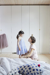 Mutter und Tochter im Schlafzimmer, von Angesicht zu Angesicht, Mutter trägt ein Stirnband mit Krone - ISF01262