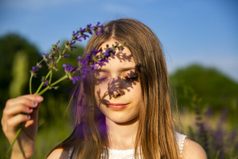Porträt eines Mädchens mit violetter Blüte in der Abenddämmerung - SARF03748