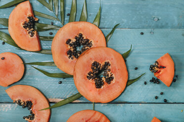 In Scheiben geschnittene Papaya auf blauem Holz - RTBF01272
