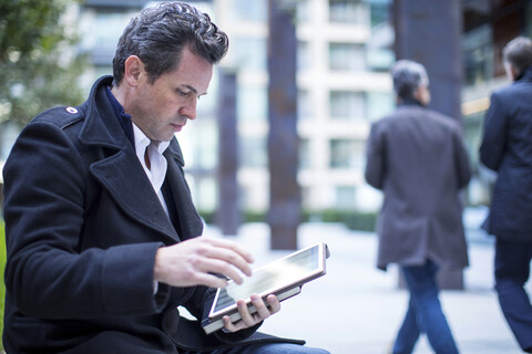 Geschäftsmann auf der Straße mit digitalem Tablet, lizenzfreies Stockfoto