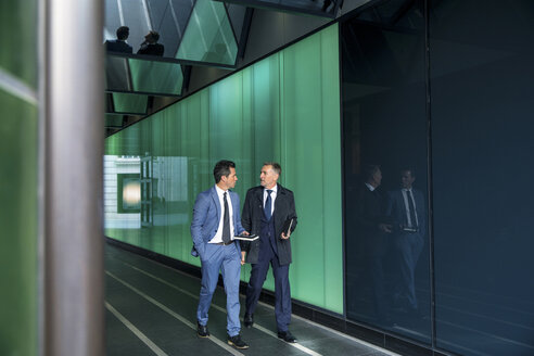 Geschäftsleute gehen durch ein modernes Glasgebäude, London, UK - CUF04910