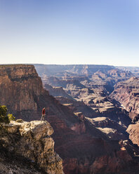 Mann, der vom Rand des Grand Canyon National Park, Arizona, USA, hinunterblickt - CUF04921