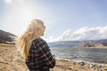 Frau mit langem blondem Haar, die auf den Lake Isabella, Kalifornien, USA, hinausschaut - CUF04933