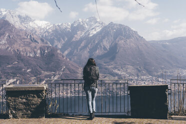 Rückansicht einer Frau mit Blick auf den See und die Berge, Monte San Primo, Italien - CUF04986