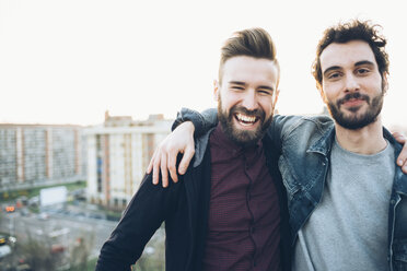 Porträt von zwei jungen Männern auf einem Dach, lächelnd - CUF05060
