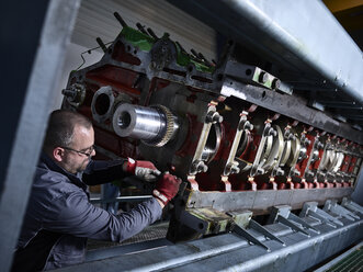 Arbeiter in der Fabrik beim Reinigen des Motorblocks - CVF00509