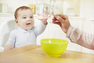 Ein kleiner Junge wird von seiner Mutter mit Frühstück gefüttert - CUF05079
