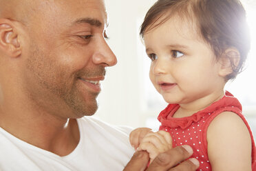 Mid adult man and baby daughter gazing at each other - CUF05095