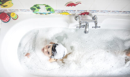 Junge in der Badewanne sitzend, Seifenblasen auf dem Kopf, lächelnd, Draufsicht - CUF05106