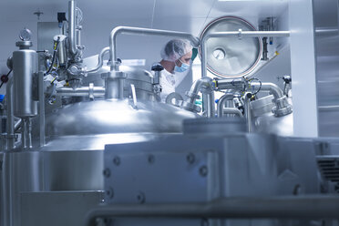 Worker operating pharmaceutical production equipment in pharmaceutical plant - CUF05108