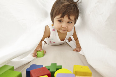 Portrait of toddler, crawling between sheets - CUF05120