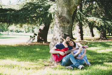 Ehepaar sitzt im Park und spielt Gitarre, Arezzo, Toskana, Italien - CUF05144