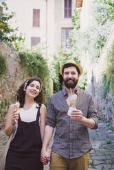 Porträt eines Paares mit Eistüten auf einer Kopfsteinpflasterstraße, Arezzo, Toskana, Italien - CUF05149