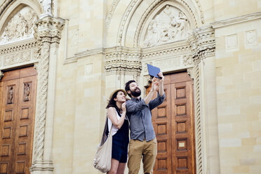 Paar, das ein digitales Tablet-Selfie vor dem Dom von Arezzo macht, Arezzo, Toskana, Italien - CUF05159