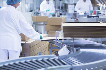 Workers packaging pharmaceutical products on production line in pharmaceutical plant - CUF05213
