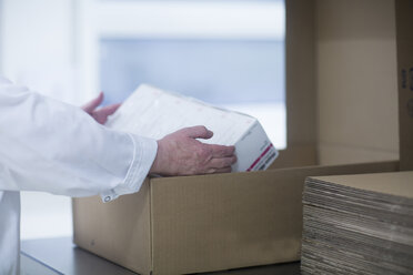 Arbeiter beim Verpacken von pharmazeutischen Produkten in einer pharmazeutischen Fabrik, Mittelteil - CUF05214