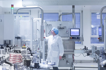 Arbeiter, der Maschinen in einer pharmazeutischen Fabrik bedient - CUF05216