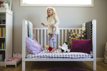 Girl jumping on day bed - CUF05219