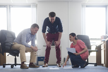 Colleagues discussing papers on office floor - CUF05337