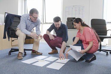 Colleagues discussing papers on office floor - CUF05338