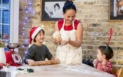 Mother and son making Christmas cookies at home - CUF05359