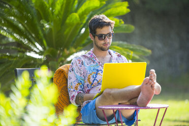 Man with feet up using laptop computer - CUF05387