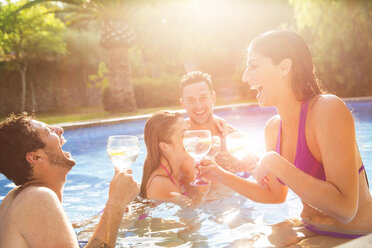 Freunde im Schwimmbad, die einen Toast aussprechen - CUF05402