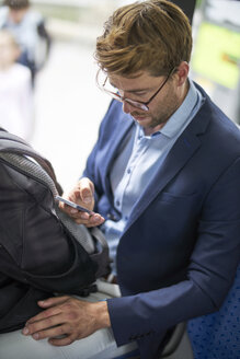 Geschäftsmann benutzt Smartphone in der U-Bahn - BEF00055