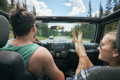 Junge Frau mit hochgelegten Füßen auf einer Autofahrt mit ihrem Freund, Breckenridge, Colorado, USA, lizenzfreies Stockfoto