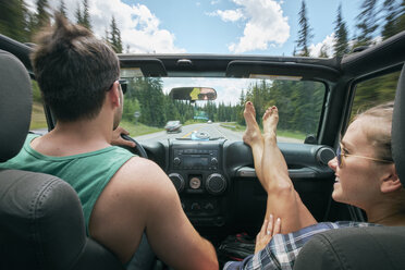 Junge Frau mit hochgelegten Füßen auf einer Autofahrt mit ihrem Freund, Breckenridge, Colorado, USA - ISF01308