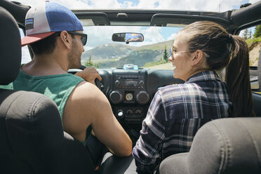 Road trip couple driving on rural road, Breckenridge, Colorado, USA - ISF01311