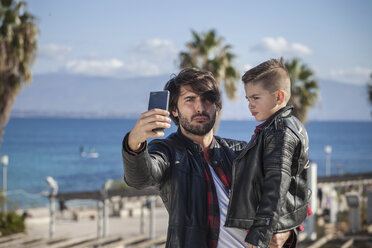 Vater und Sohn im Freien, Vater macht Selfie mit Smartphone - ISF01316