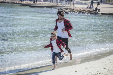 Vater und Sohn laufen am Strand entlang - ISF01324