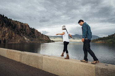 Couple walking along wall beside Dillon Reservoir, Silverthorne, Colorado, USA - ISF01351